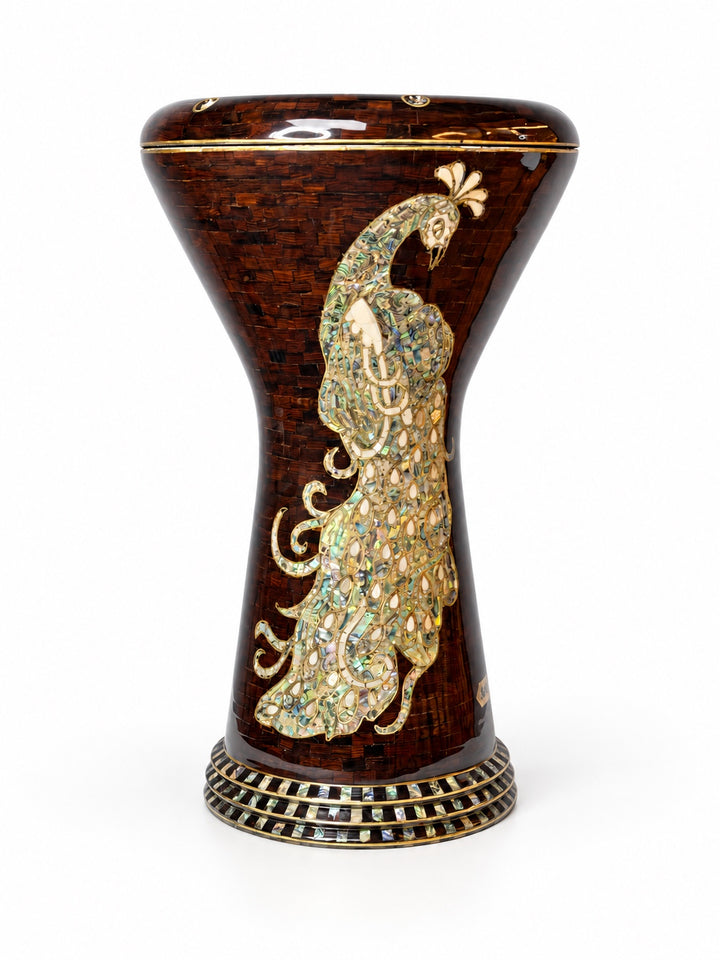 Sala Amber Peacock Sombaty دربوكة واقفة منتصبة، تظهر شكل طاووس شاحب على خلفية فسيفساء بنية كهرمانية داكنة.