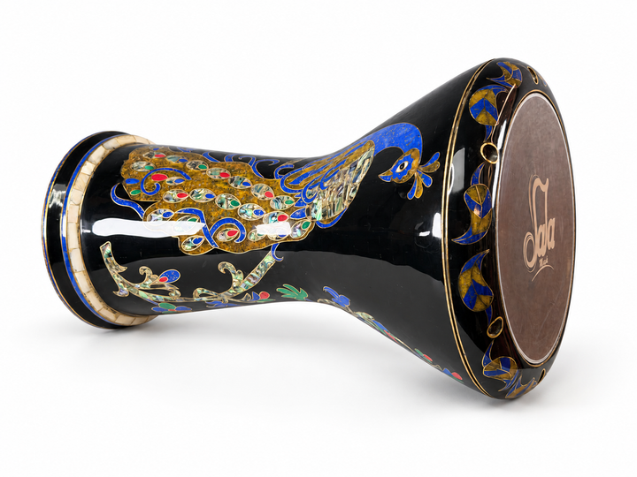 Sala Midnight Peacock Sombaty دربوكة على جانبها، تظهر رأس الطبلة الذي يحمل العلامة التجارية Sala وطاووس باللونين الأزرق والذهبي مع تفاصيل ذيل ملونة بلمسة نهائية داكنة.